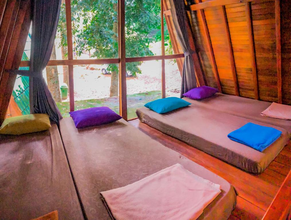 um quarto com duas camas e uma janela em Wonderful Citamiang by Anrha em Puncak
