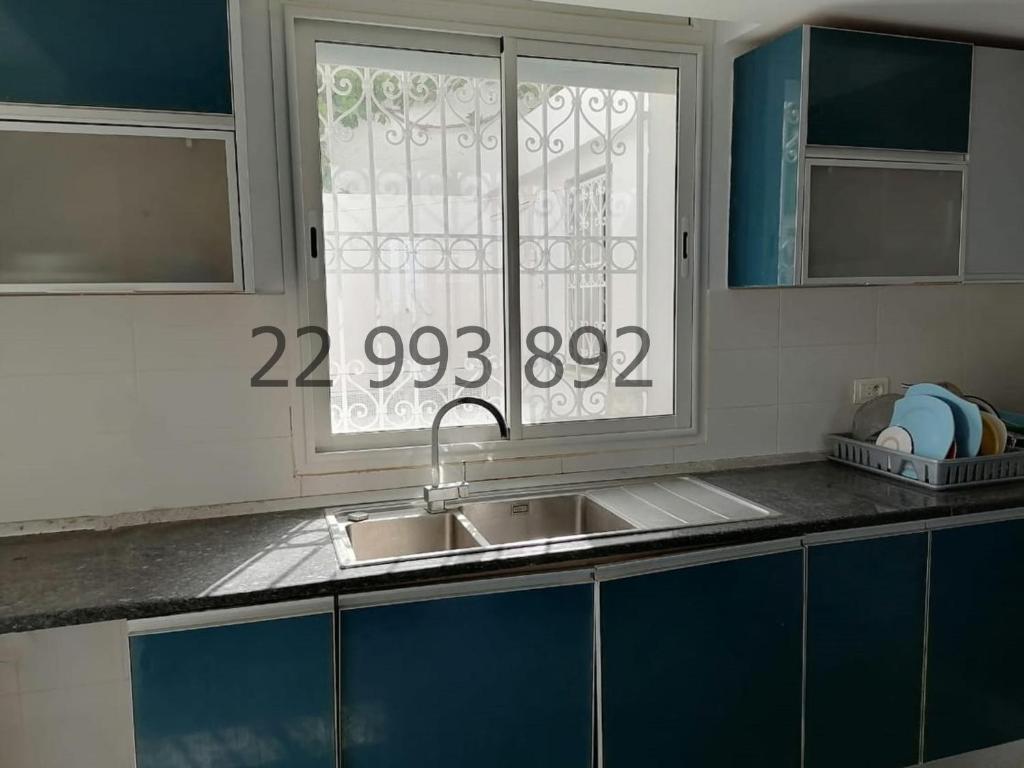 uma cozinha com um lavatório e uma janela em villa s+5 pied dans l'eau Plage Ezzahra 22993892 em Kelibia