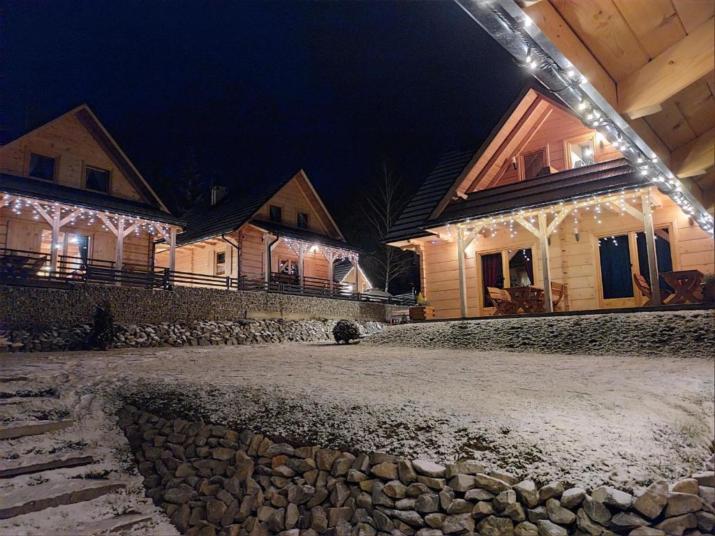 un grupo de casas con luces de Navidad en ellas en Domek w Borowikowym Zaciszu, en Falsztyn
