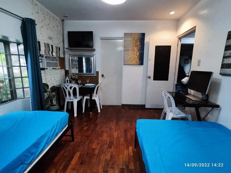 Habitación con 2 camas y mesa con ordenador portátil. en JOIZ HOMESTAY en San Pedro