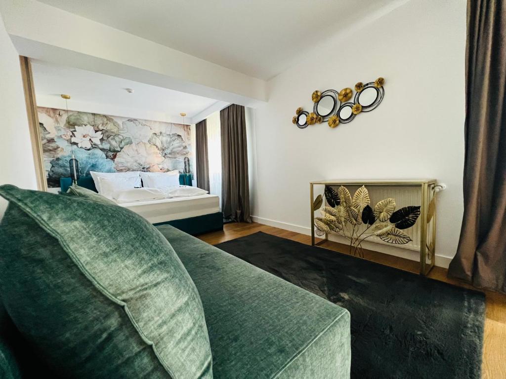 uma sala de estar com um sofá verde e uma cama em Boutique Villa Isabelle em Predeal