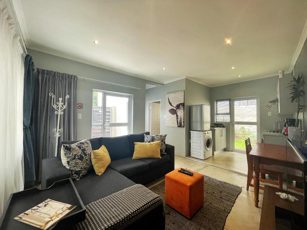 ein Wohnzimmer mit einem Sofa und einem Tisch in der Unterkunft Alon Cottage in Johannesburg