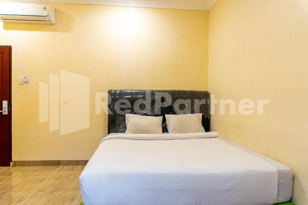 a bedroom with a large bed in a room at Adam Malik Guesthouse near Regale ICC Medan Mitra RedDoorz in Medan
