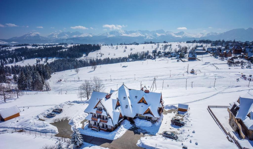 ゾンプにあるHotel REDYK Ski&Relaxの雪に覆われた家屋の空見