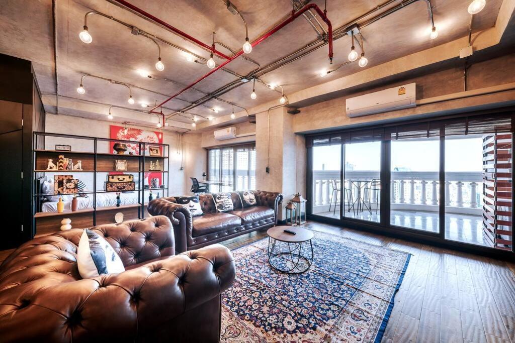 Central Bangkok Loft Style Skyline 100 sq.m. Apt في بانكوك: غرفة معيشة كبيرة مع أريكة وطاولة