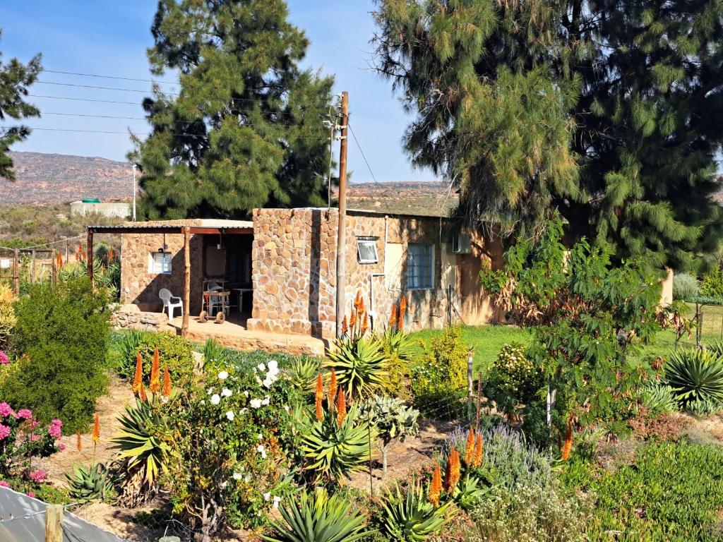 a stone house with a garden in front of it at Neels Cottage in Clanwilliam