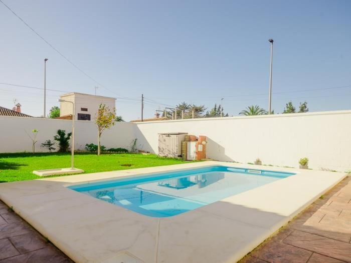 a swimming pool in the backyard of a house at Villa Malvasía in Chiclana de la Frontera