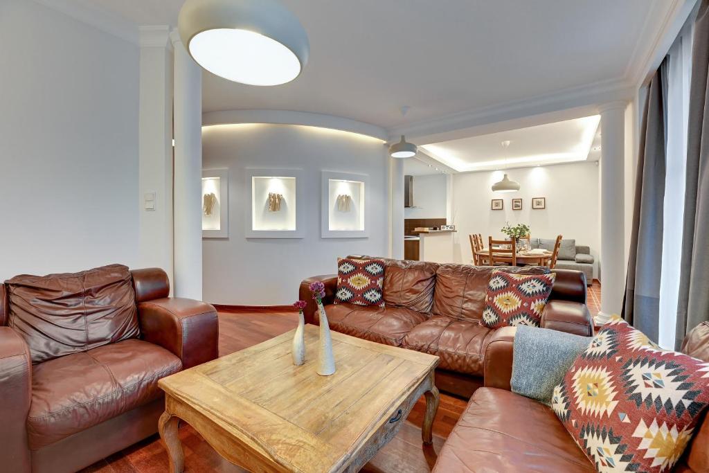uma sala de estar com sofás de couro e uma mesa em Lion Apartments - Portofino Familly Apartment at the city center with parking em Sopot