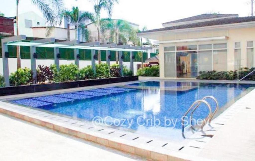 a swimming pool in front of a building at OYO 923 Cozy Crib By Shey in Manila