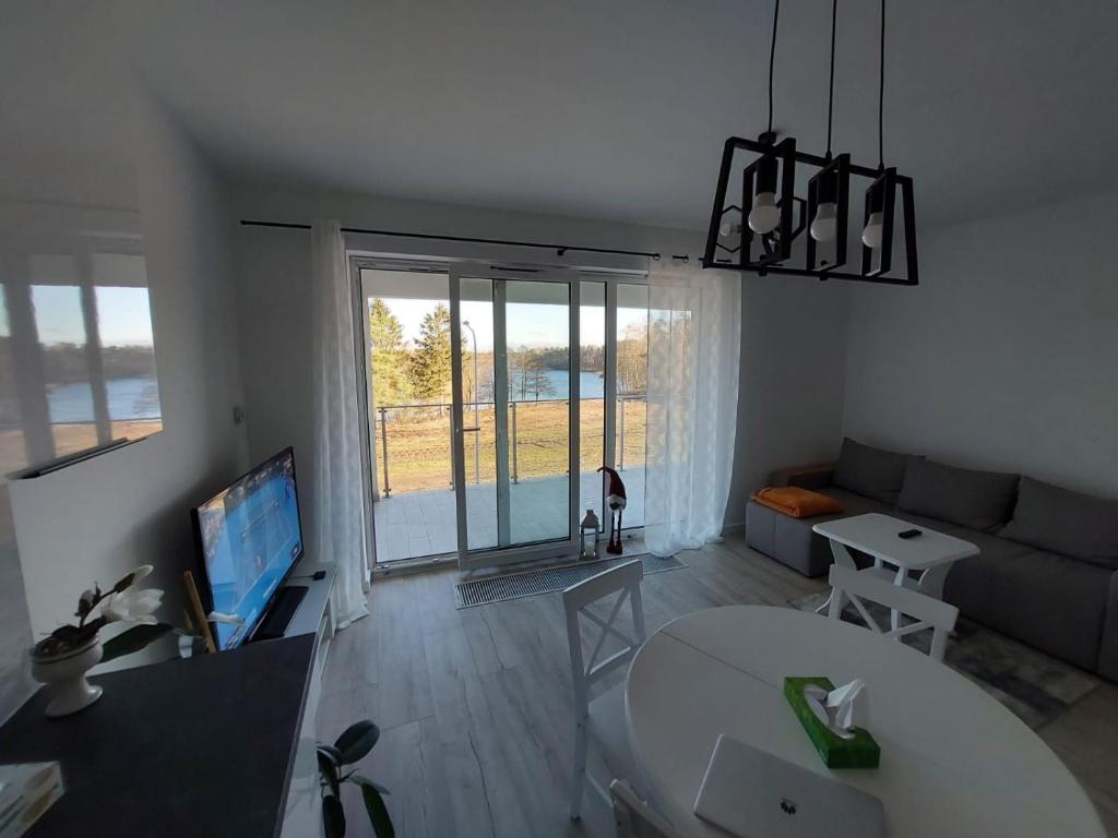 Televízia a/alebo spoločenská miestnosť v ubytovaní Apart Białe Augustów