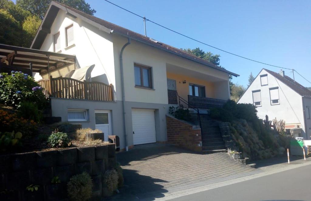 a white house with a staircase in front of it at Ferienwohnung-Michelle in Waldrach