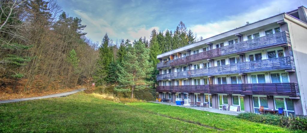 a large building with a yard in front of it at Apartmán na kraji lesa Všemina in Všemina