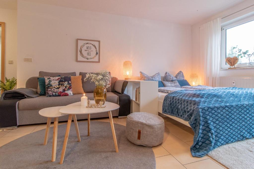 sala de estar con cama y sofá en Modernes Apartment im Grünen I Balkon I WLAN I Stellplatz, en Schwarzenberg