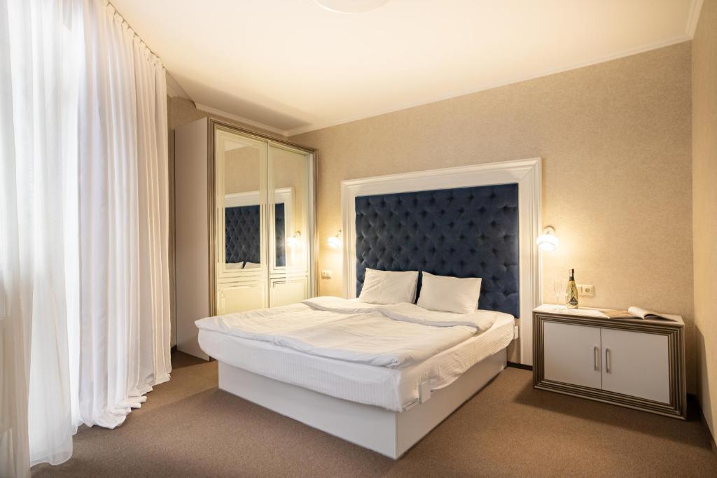 una camera con un grande letto con testiera blu di Private Rooms in Hotel Lift 1R a Bukovel