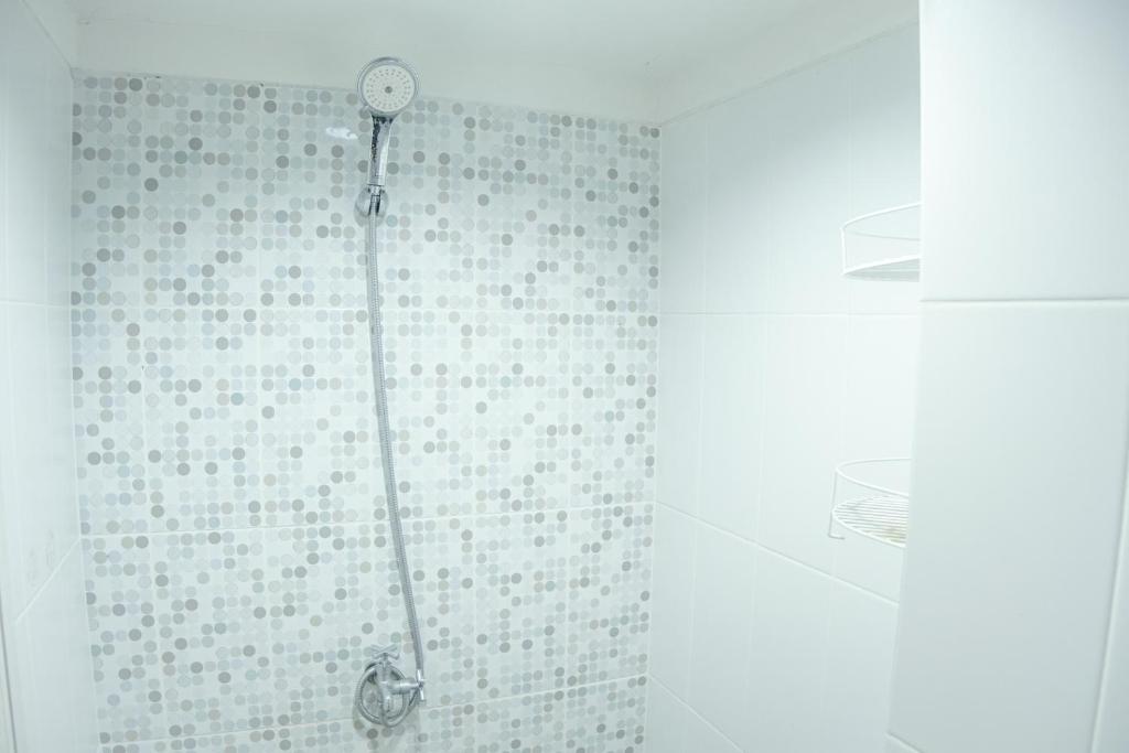 La salle de bains est pourvue d'une douche avec un pommeau de douche. dans l'établissement Kia Servised Apartmen at Grand Sentraland Karawang, à Karawang