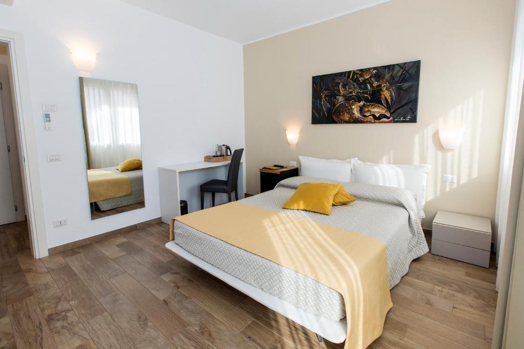 a white bedroom with a bed and a desk at Casa Mafalda in Chioggia