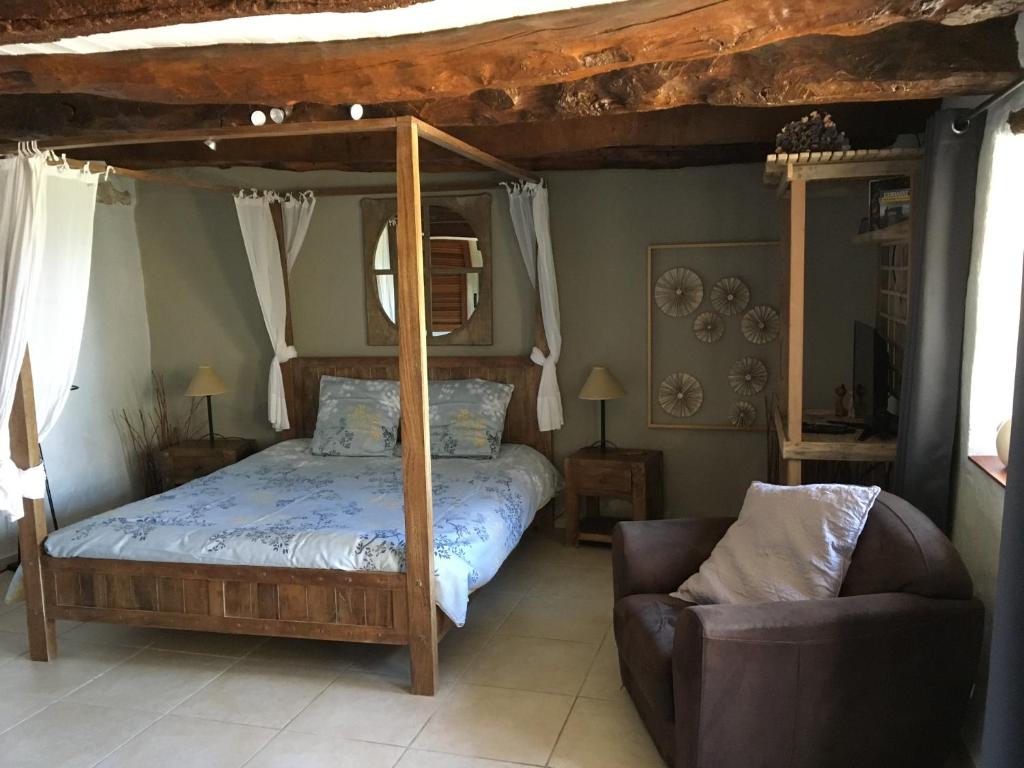 Ferme de Simondon في Plats: غرفة نوم مع سرير مظلة وأريكة