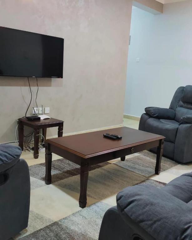 - un salon avec une table basse et une télévision à écran plat dans l'établissement COSY MTWAPA THREE BEDROOM APARTMENT, à Mombasa