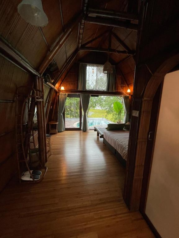 a room with a bed and a wooden floor at Villa Baan Pak Pra in Ban Pak Pra (1)