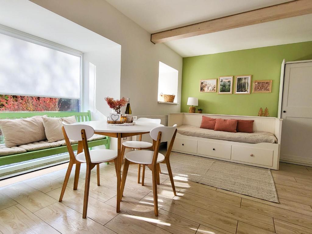 uma sala de jantar com uma mesa e cadeiras e uma cama em Apartmány u Koláčků em Hartmanice