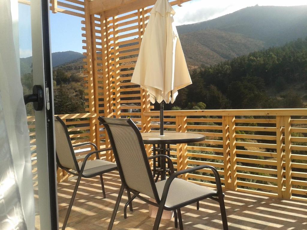 - un balcon avec une table, des chaises et un parasol dans l'établissement Condominio Los Miradores, à Papudo