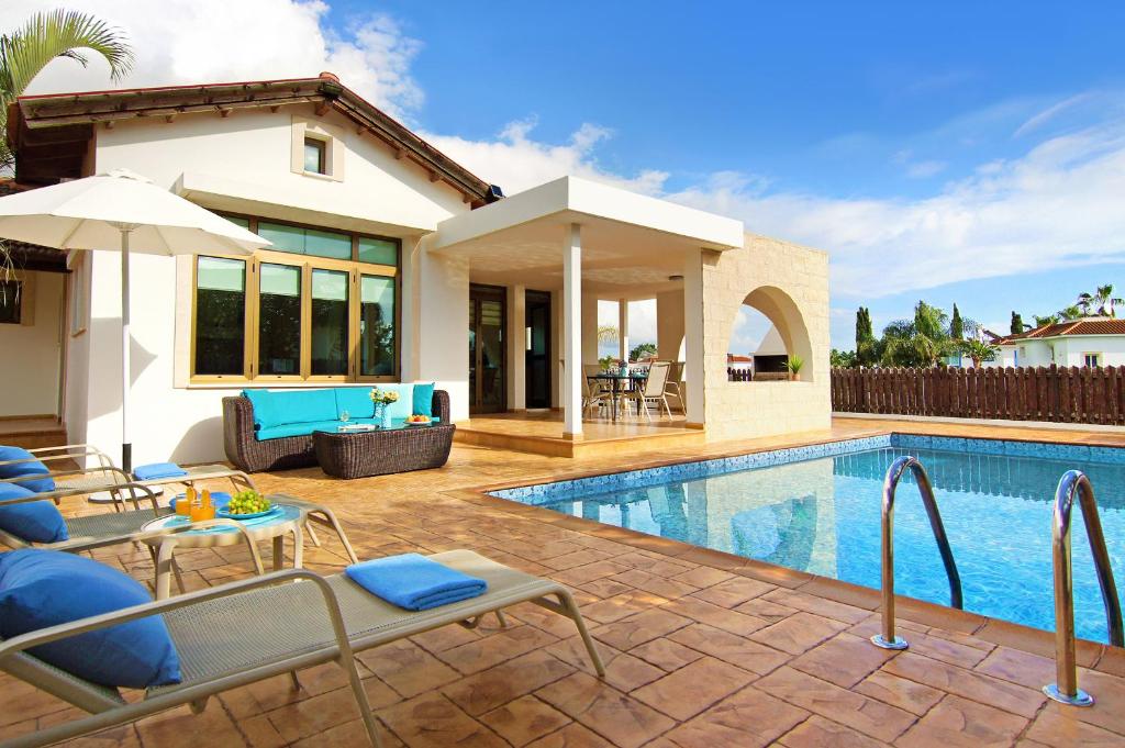a villa with a swimming pool and a house at Villa Merry in Ayia Napa