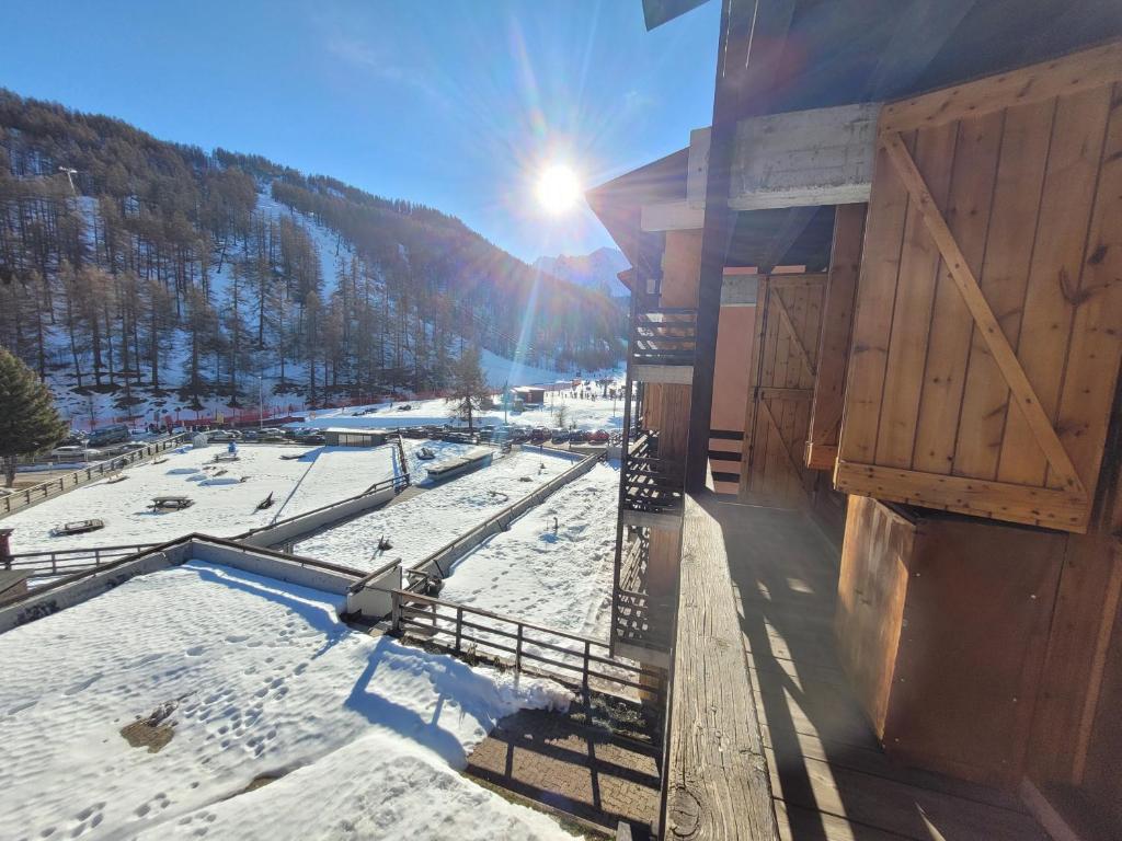 a ski lodge with the sun shining on the snow at Over The Snow Apartment in Borgata Sestriere
