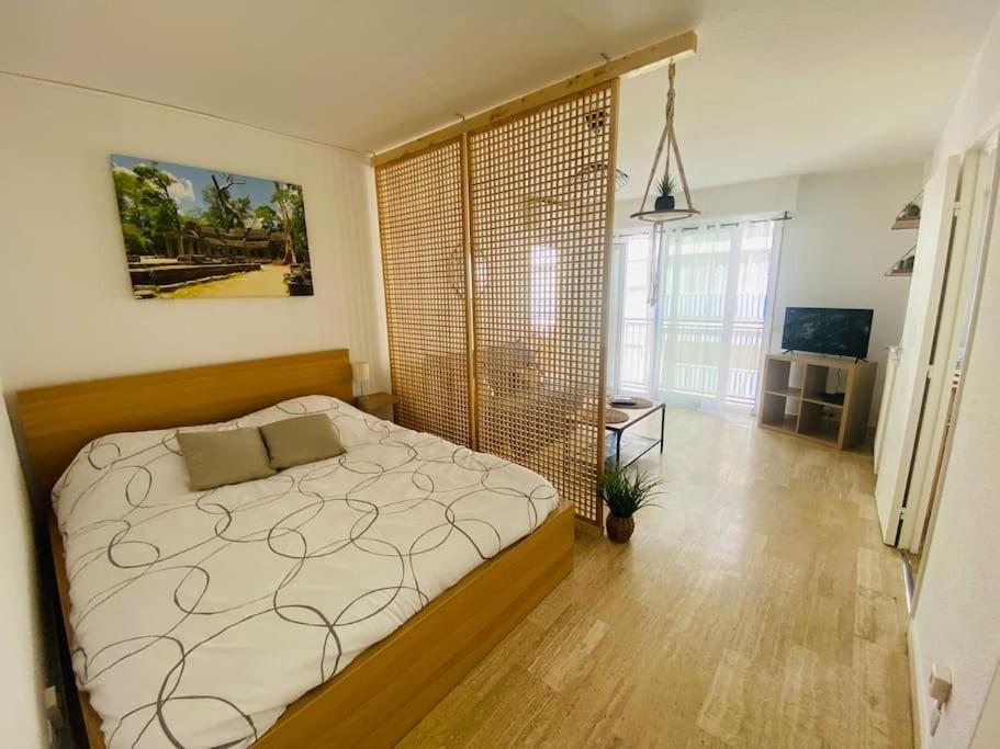 une chambre avec un lit et une grande fenêtre dans l'établissement Confort - Appartement Cosy - Proche Mer ***, à Vallauris