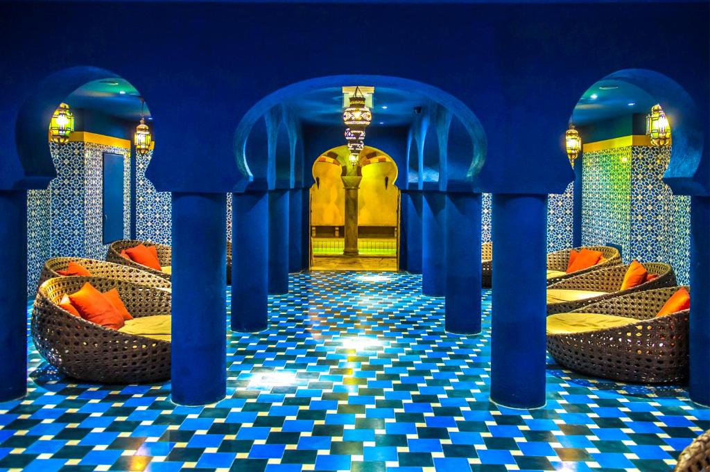 a room with blue columns and a checkered floor at Shiraz Hotel Superior in Egerszalók