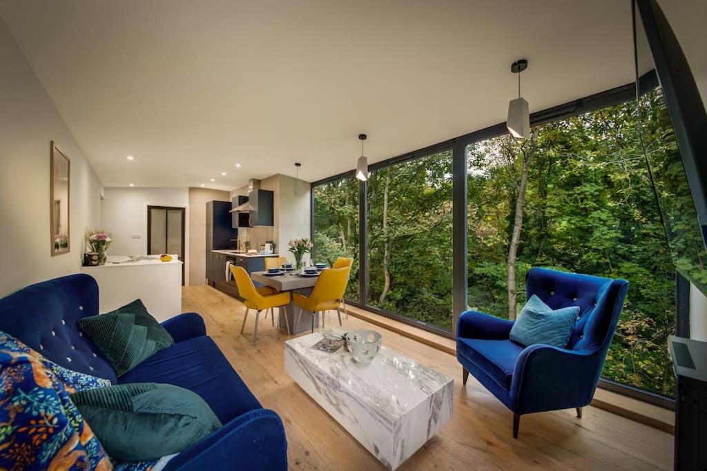 a living room with a blue couch and yellow chairs at The Keep at Castlegate - Luxury detached retreat in Cragg vale, Hebden Bridge in Mytholmroyd