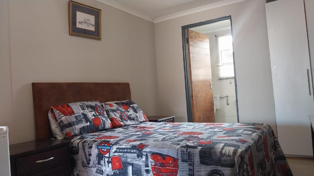 een slaapkamer met een bed met een quilt bij Jay's Guest House in Witbank