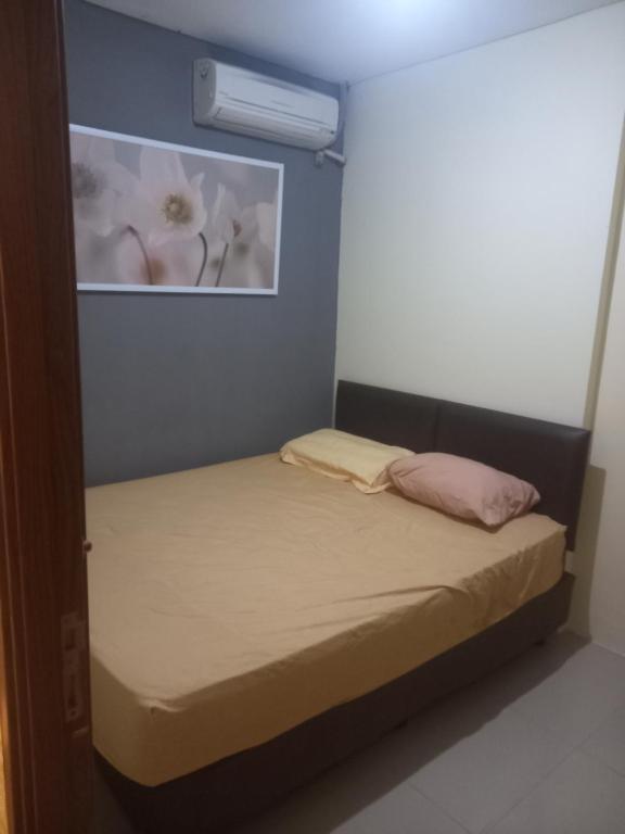een kleine slaapkamer met een bed en een foto aan de muur bij Northland ancol seaview in Jakarta