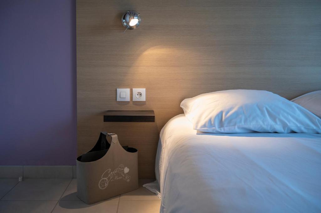a bedroom with a bed with a bag next to it at La petite maison 4 in Avoine