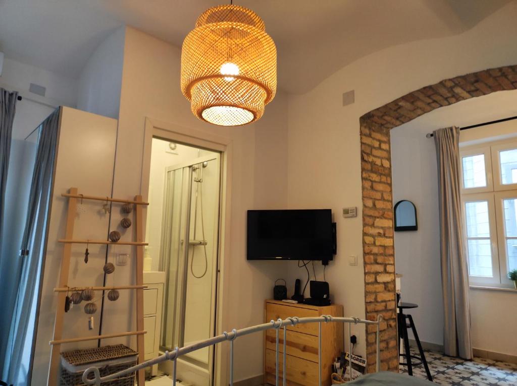 a room with a television and a chandelier at Studio apartment Frano in Zagreb