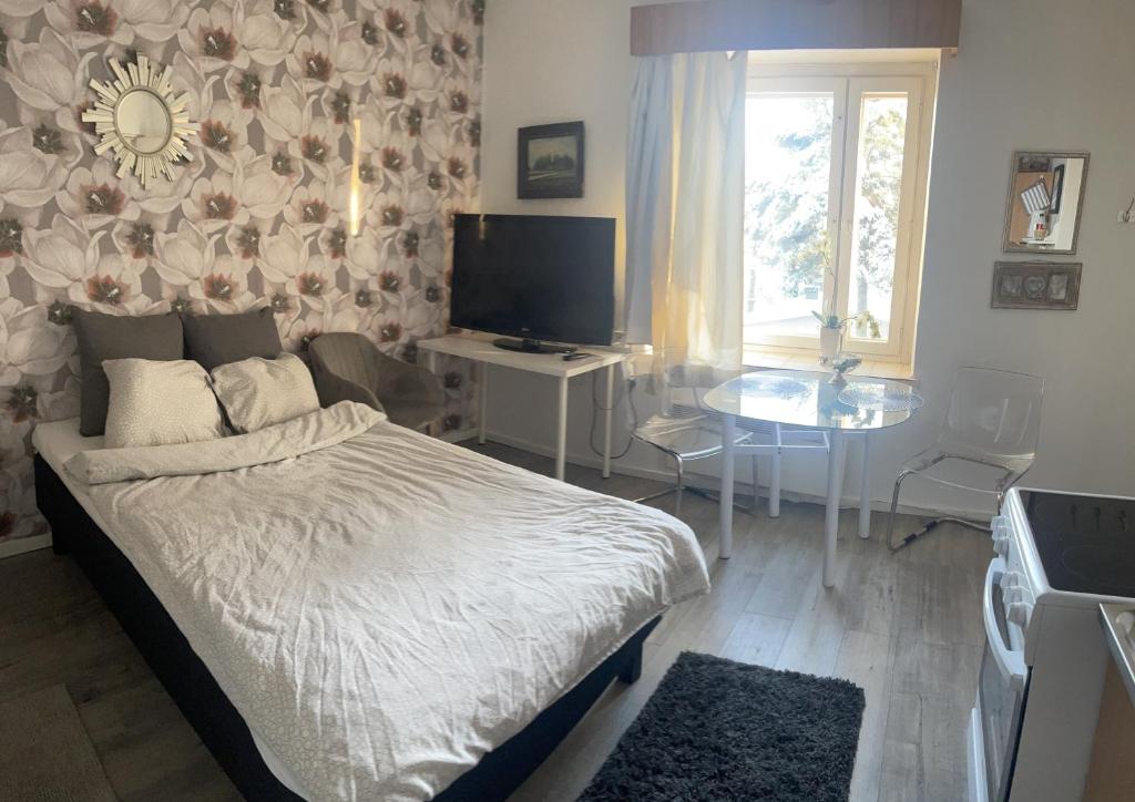 トゥルクにあるYksiö 1,5 km Kupittaalta / 3 km Turun keskustastaのベッドとテーブルとテレビのある寝室