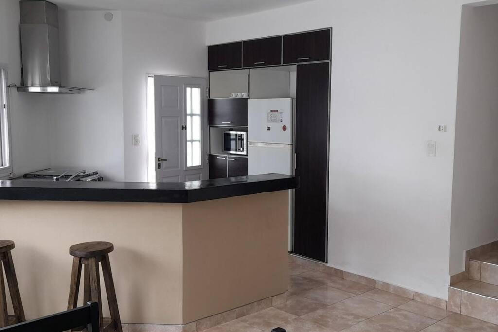 une cuisine avec des appareils en noir et blanc et un comptoir dans l'établissement Casa con vista a las sierras, à Santa María
