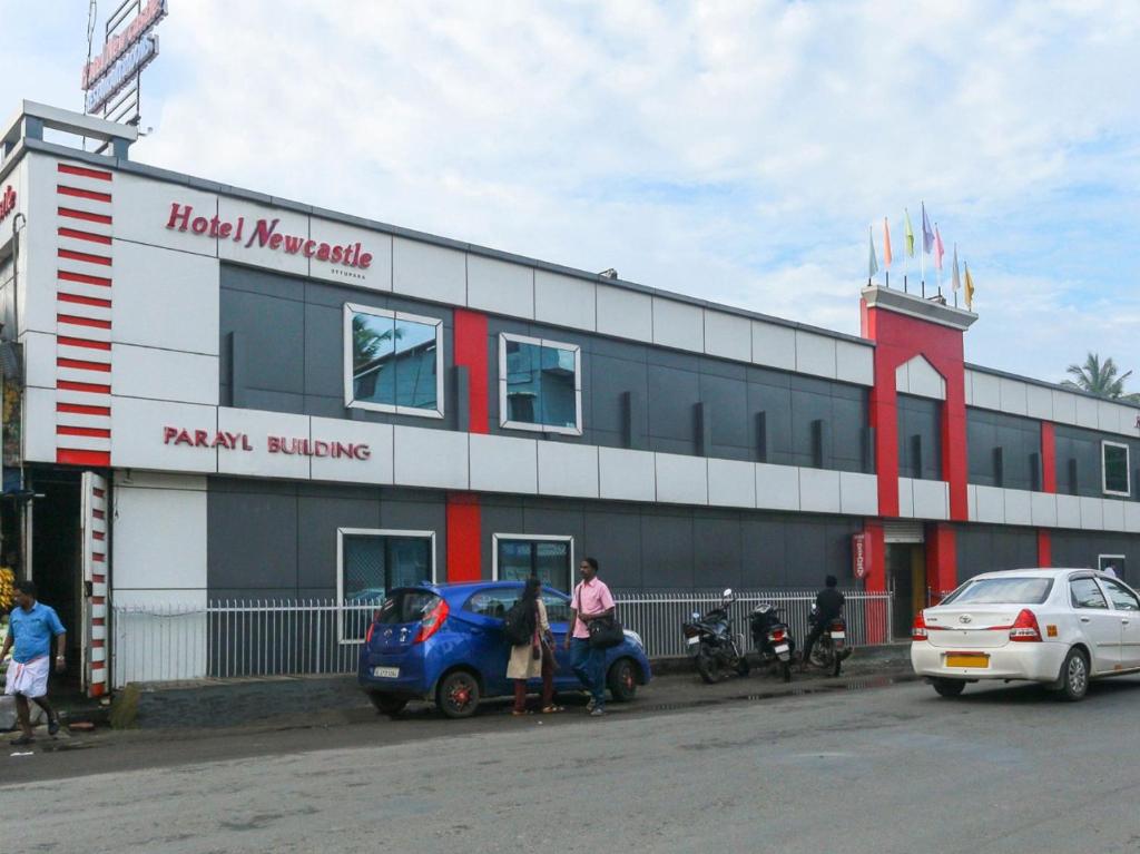 um edifício com um carro estacionado em frente em HOTEL NEWCASTLE em Vadakkāncheri