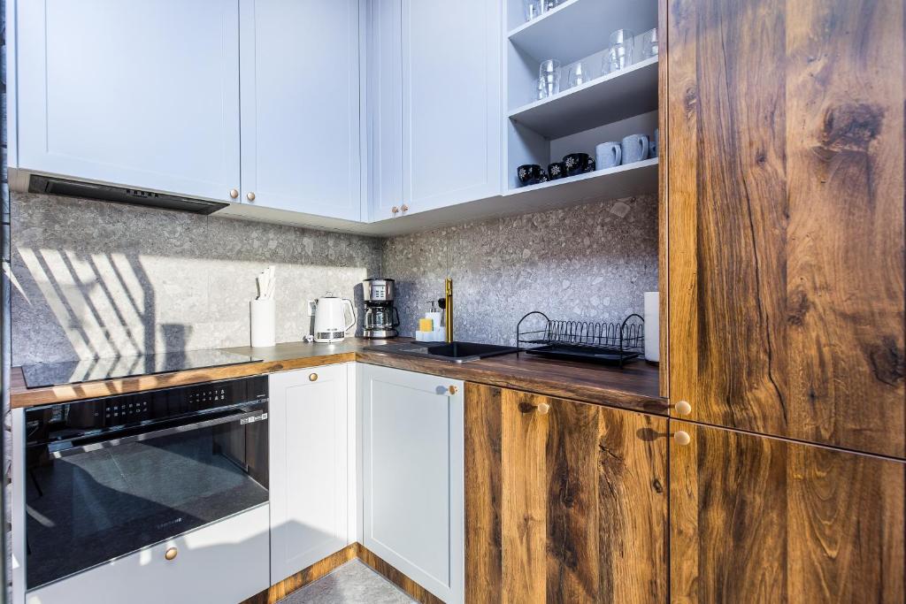 Compact kitchen corner with wood countertops, white cabinets, coffee maker and black sink.