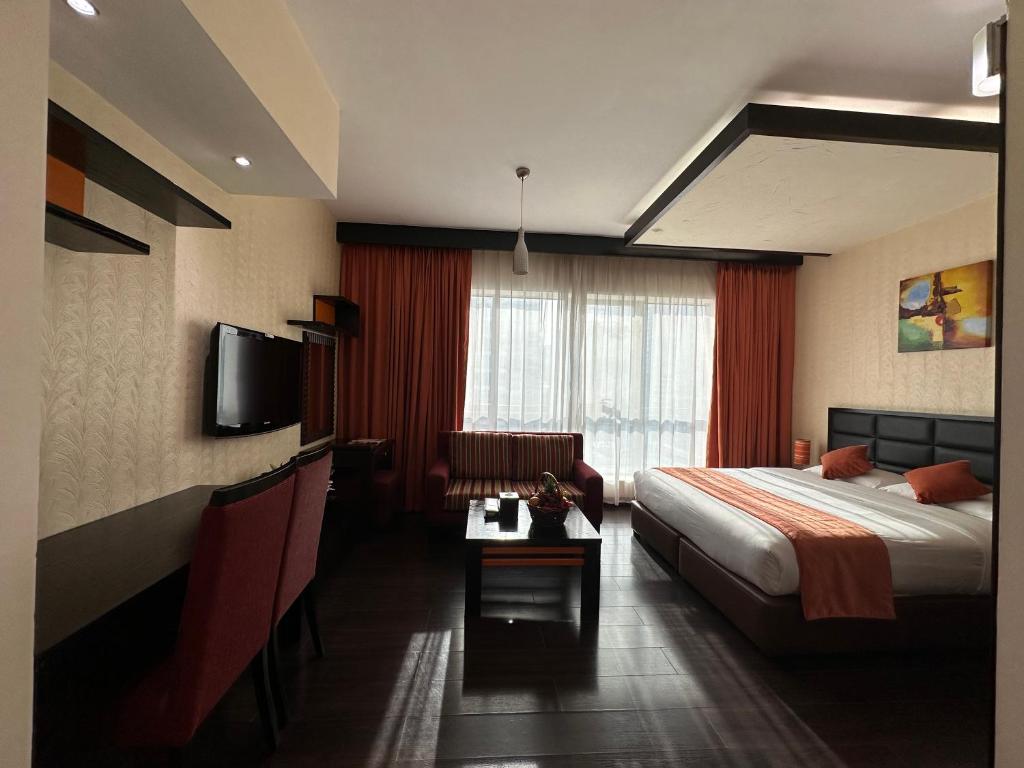 a hotel room with a bed and a television at Marina View Deluxe Hotel Apartment in Dubai