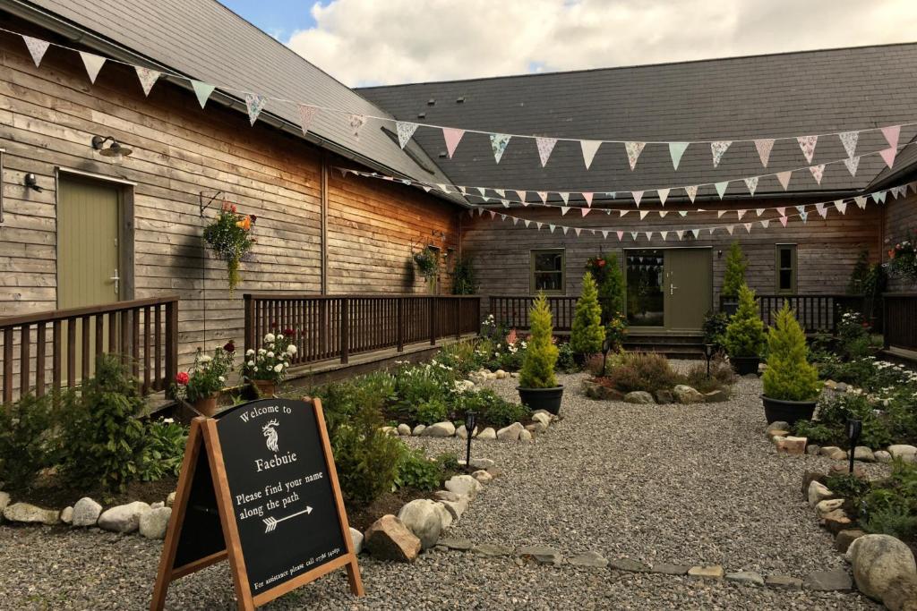 a garden with a sign in front of a building at Faebuie Cottages in Dalchreichart