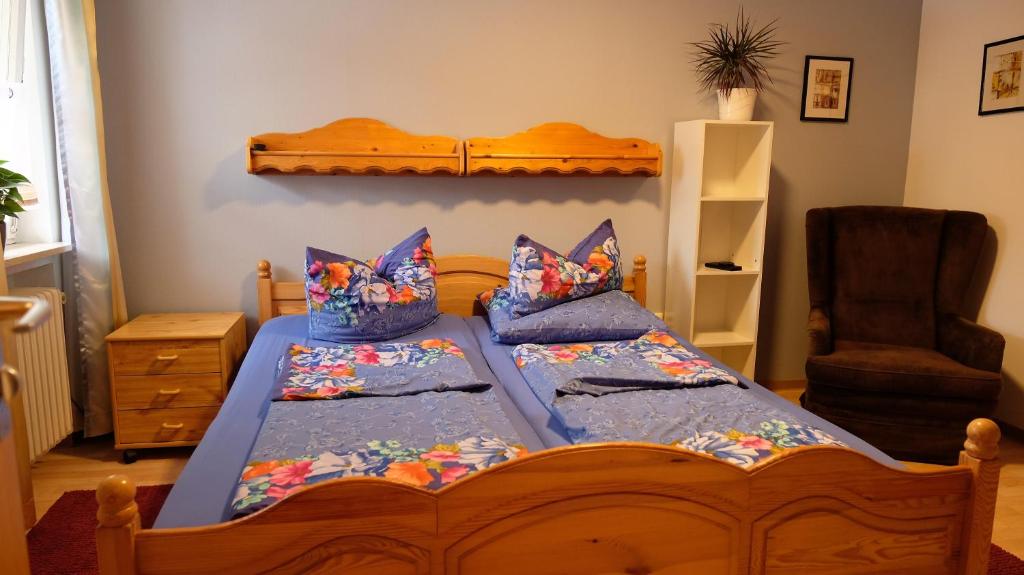 Un dormitorio con una gran cama de madera con almohadas en Pension Schwarze Berge, 