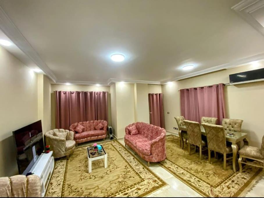 Dreams House in Maadi في القاهرة: غرفة معيشة بأثاث وردي وطاولة