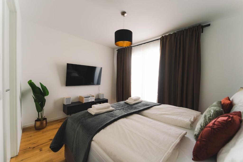 1 dormitorio con 1 cama, TV y ventana en Triangle City Apartment II, en Viena