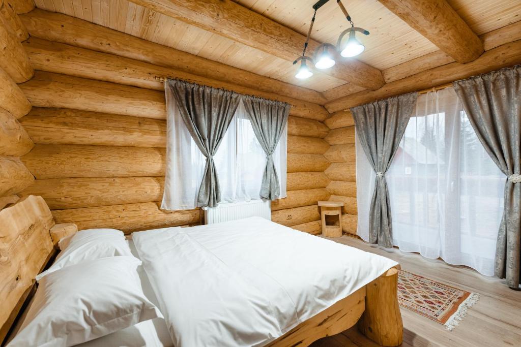 um quarto com uma cama num chalé de madeira em Rustic Chalet em Călăţele