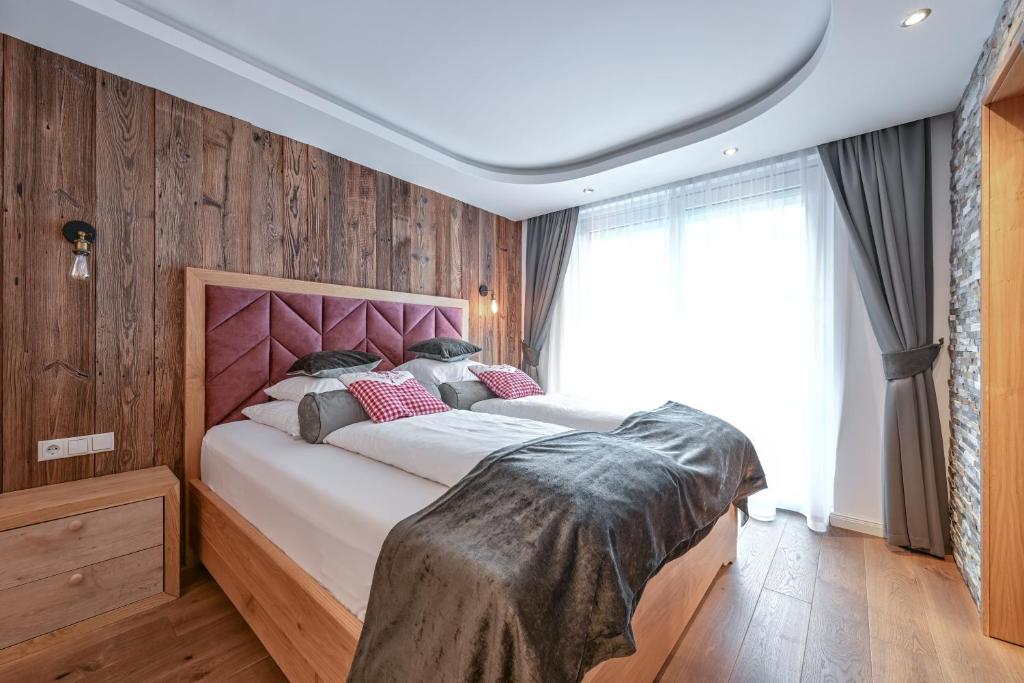 オエッツにあるVilla Ambachのベッドルーム1室(ピンクのヘッドボード付きの大型ベッド1台付)