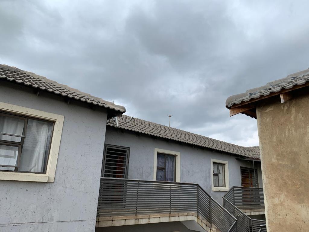 a white house with a balcony on the side of it at Orlando Manor in Soweto