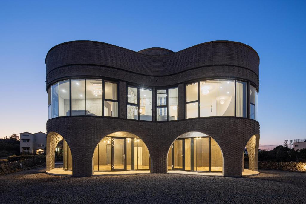 a large black building with glass windows at Luxury Pool Villa, Villecot in Seogwipo