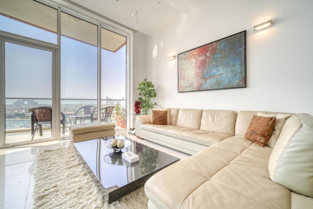sala de estar con sofá y ventana grande en Tiara Residences, Palm Jumeirah Dubai - Mint Stay en Dubái
