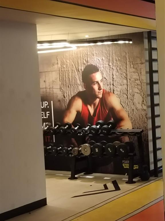 una foto de un hombre en un gimnasio con pesas en Arte plus by Sweet home en Kuala Lumpur