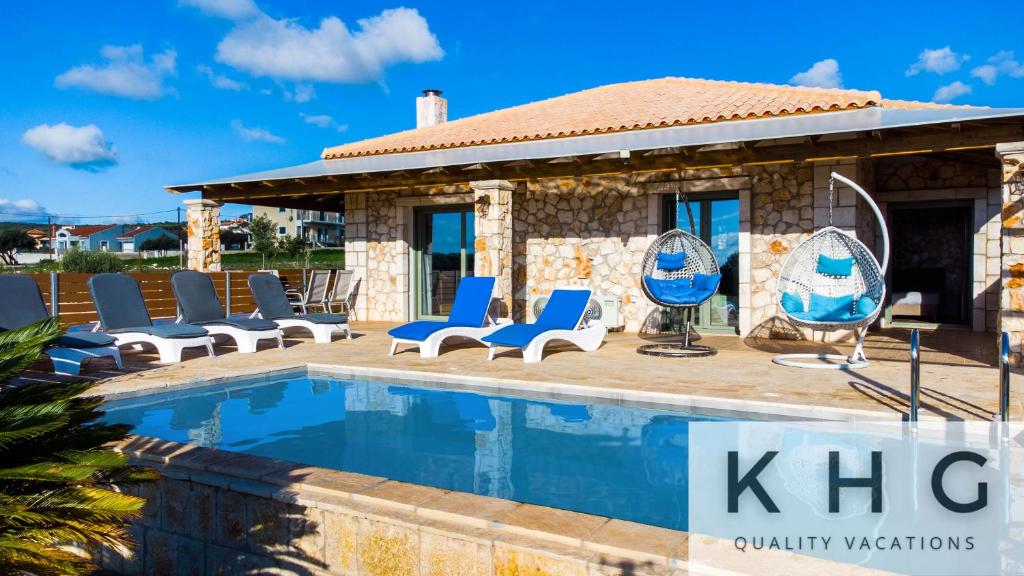 a villa with a swimming pool and lounge chairs at Leo's Stone made Villa! in Karavadhos